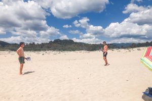 due ragazzi giocano a racchettoni in spiaggia