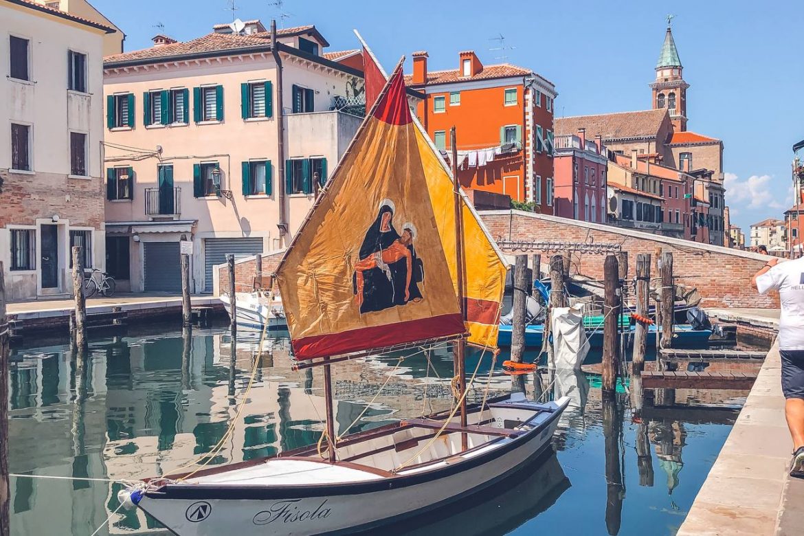 immagine tipica di pioggia con barche nel canale e un ponte